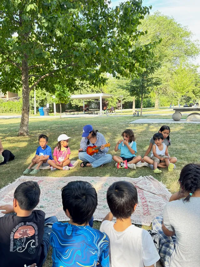 Children and youth gathered outdoors under a tree for a devotional gathering